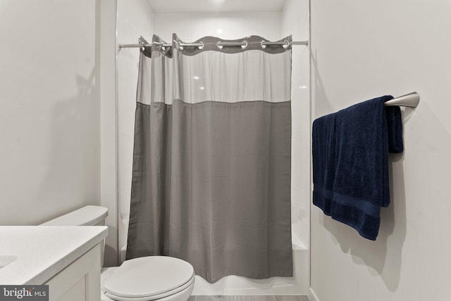 bathroom with toilet, shower / bath combination with curtain, and vanity