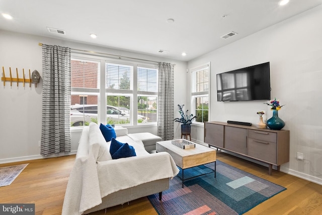 living area featuring wood finished floors, baseboards, and recessed lighting