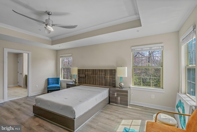 10648 Cheryl Turn, Waldorf, MD 20603 - bedroom featuring multiple windows, baseboards, light wood-type flooring, a tray ceiling, and ornamental molding