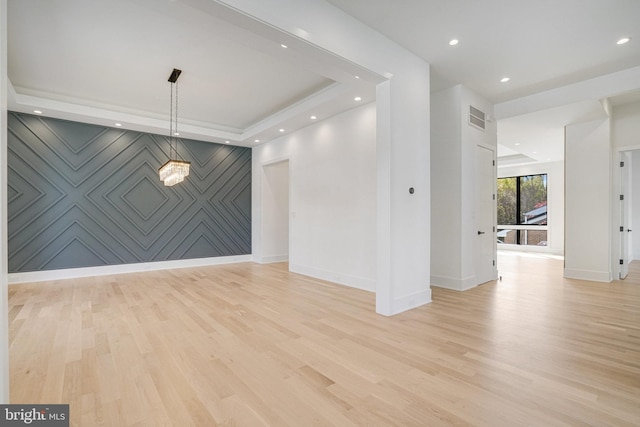 spare room with baseboards, light wood-style floors, an accent wall, recessed lighting, and a chandelier