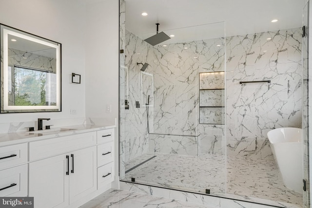bathroom featuring marble tiled flooring, a marble finish shower, recessed lighting, vanity, and a freestanding tub