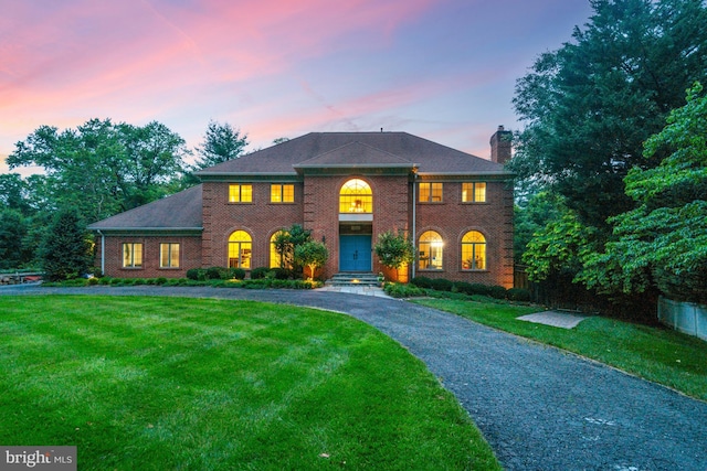1016 Bellview Rd, Mclean, VA 22102 - colonial-style house with a front lawn, brick siding, a chimney, and curved driveway
