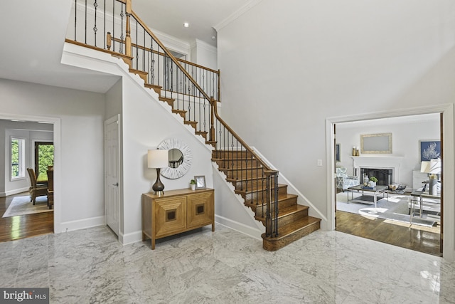 1016 Bellview Rd, Mclean, VA 22102 - stairs with crown molding, a fireplace, marble finish floors, and a towering ceiling