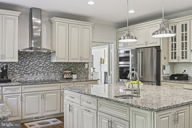 1016 Bellview Rd, Mclean, VA 22102 - kitchen with wall chimney range hood, appliances with stainless steel finishes, backsplash, a center island with sink, and crown molding