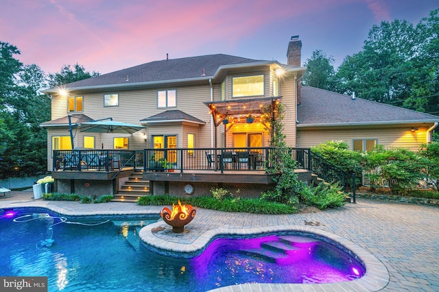 1016 Bellview Rd, Mclean, VA 22102 - back of house at dusk featuring a wooden deck, a chimney, a patio, and a jacuzzi