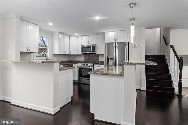6867 Happyheart Ln, Columbia, MD 21045 - kitchen with stainless steel appliances, dark wood-style flooring, stone countertops, white cabinets, and hanging light fixtures