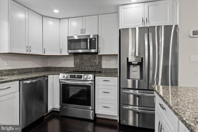 6867 Happyheart Ln, Columbia, MD 21045 - kitchen featuring stainless steel appliances, white cabinetry, dark stone counters, dark wood-type flooring, and recessed lighting