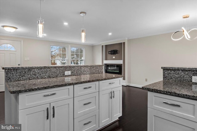 6867 Happyheart Ln, Columbia, MD 21045 - kitchen with ornamental molding, white cabinets, dark stone counters, a center island, and baseboards