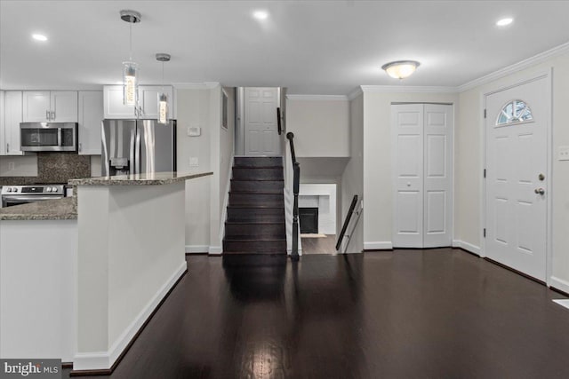 6867 Happyheart Ln, Columbia, MD 21045 - kitchen with stainless steel appliances, baseboards, light stone counters, white cabinets, and crown molding