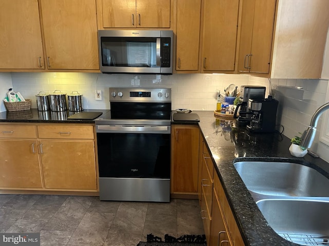 313 E Cherry St, Palmyra, PA 17078 - kitchen featuring appliances with stainless steel finishes, a sink, decorative backsplash, and dark stone counters