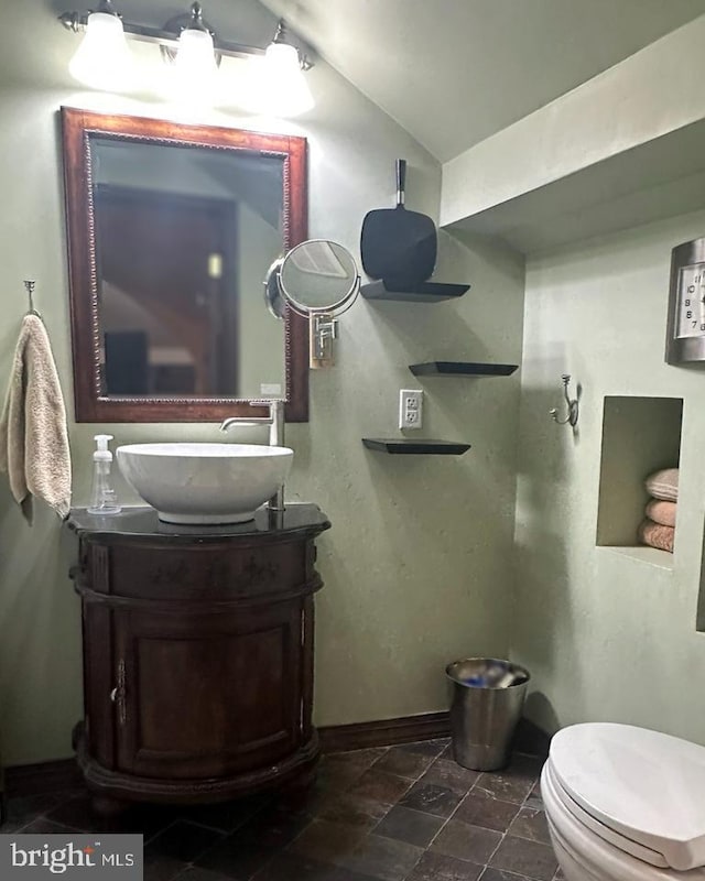 313 E Cherry St, Palmyra, PA 17078 - bathroom with lofted ceiling, vanity, baseboards, stone finish floors, and toilet