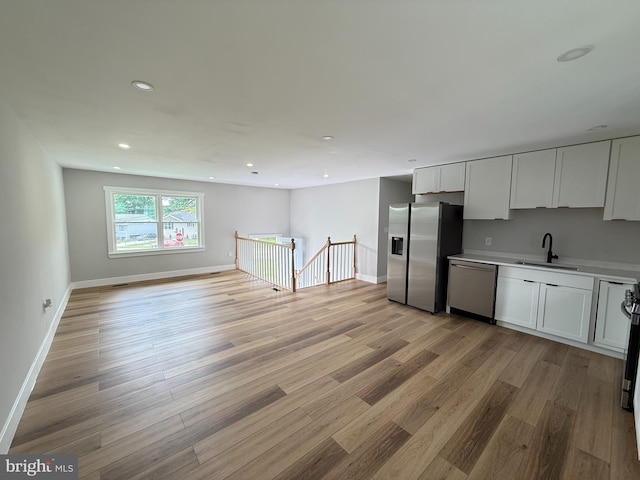8110 Manson St, Landover, MD 20785 - kitchen with appliances with stainless steel finishes, a sink, light countertops, light wood finished floors, and white cabinets