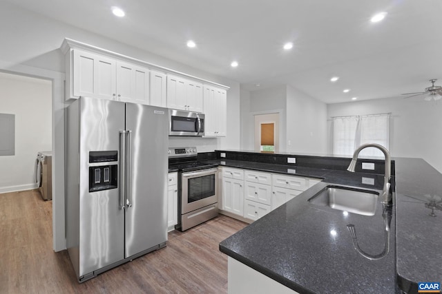 6169 Community House Rd, Columbia, VA 23038 - kitchen featuring appliances with stainless steel finishes, a sink, washer and dryer, wood finished floors, and recessed lighting