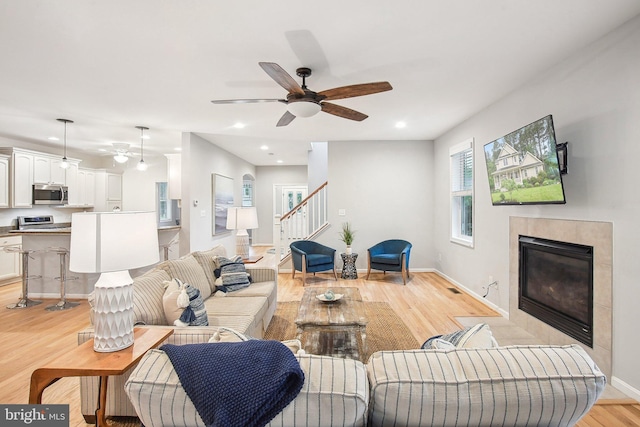 34637 Megan Ct, Lewes, DE 19958 - living area featuring ceiling fan, stairway, a tiled fireplace, recessed lighting, and light wood-style flooring