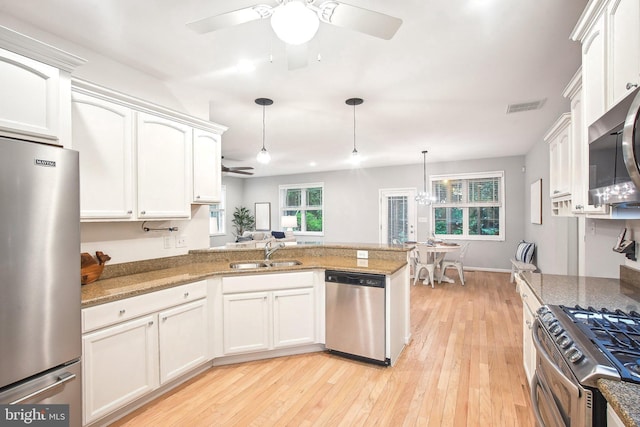 34637 Megan Ct, Lewes, DE 19958 - kitchen featuring appliances with stainless steel finishes, a sink, a ceiling fan, a peninsula, and healthy amount of natural light