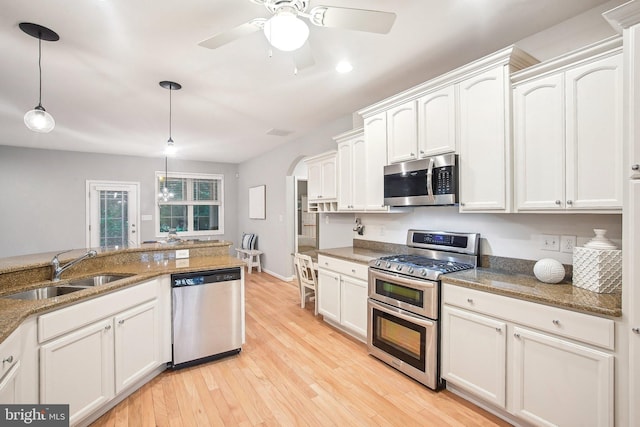 34637 Megan Ct, Lewes, DE 19958 - kitchen with stainless steel appliances, a sink, ceiling fan, pendant lighting, and arched walkways