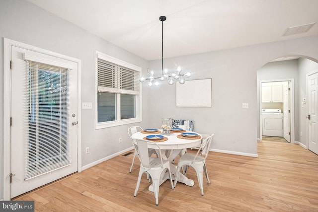 34637 Megan Ct, Lewes, DE 19958 - dining space featuring washer / dryer, arched walkways, baseboards, light wood finished floors, and a chandelier