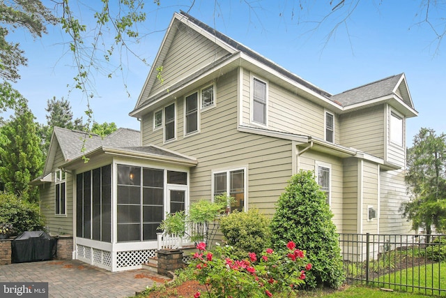 34637 Megan Ct, Lewes, DE 19958 - view of property exterior featuring a sunroom, a patio area, and roof with shingles