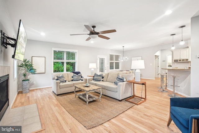 34637 Megan Ct, Lewes, DE 19958 - living room with light wood-style flooring, arched walkways, a ceiling fan, baseboards, and a fireplace