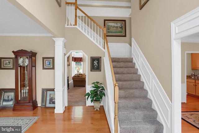 1016 Saddleback Way, Bel Air, MD 21014 - stairs featuring wood finished floors, decorative columns, wainscoting, ornamental molding, and a decorative wall