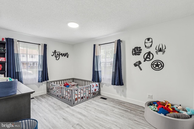 76 Torrington Ln, Willingboro, NJ 08046 - bedroom with a textured ceiling, wood finished floors, baseboards, and a crib
