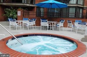 1001 N Randolph St Unit 720, Arlington, VA 22201 - view of swimming pool featuring a community hot tub, a patio, and outdoor dining space