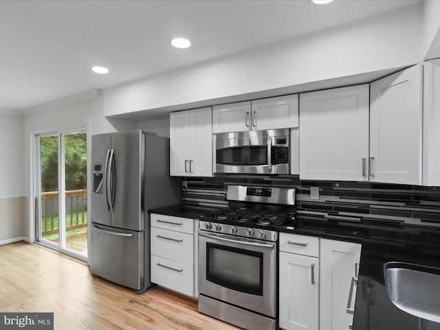 4102 Elizabeth St, Rockville, MD 20853 - kitchen featuring appliances with stainless steel finishes, tasteful backsplash, dark countertops, light wood finished floors, and ornamental molding
