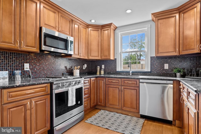 917 Foulkrod St, Philadelphia, PA 19124 - kitchen with stainless steel appliances, a sink, brown cabinets, light wood-type flooring, and recessed lighting