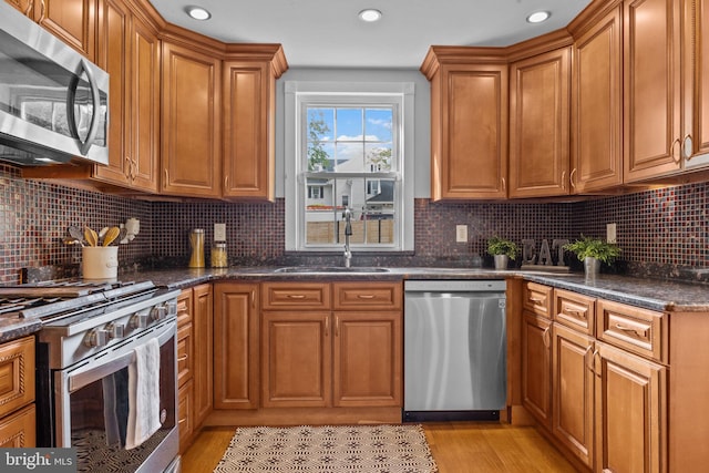 917 Foulkrod St, Philadelphia, PA 19124 - kitchen featuring stainless steel appliances, a sink, brown cabinets, light wood-style floors, and recessed lighting