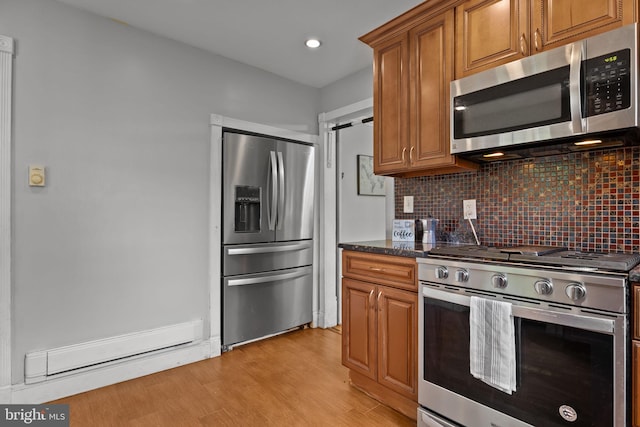 917 Foulkrod St, Philadelphia, PA 19124 - kitchen featuring appliances with stainless steel finishes, a baseboard heating unit, decorative backsplash, brown cabinetry, and recessed lighting