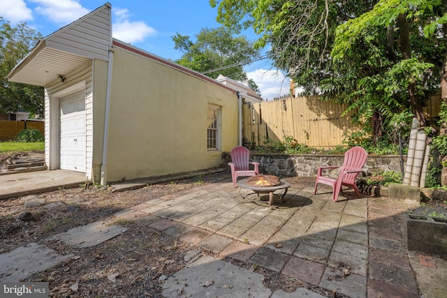 917 Foulkrod St, Philadelphia, PA 19124 - view of patio featuring an outdoor fire pit, fence, and a garage