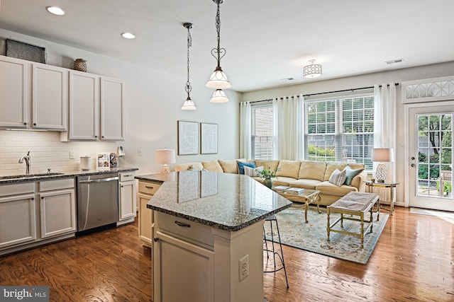 20337 Charter Oak Dr, Ashburn, VA 20147 - kitchen with dishwasher, a sink, a kitchen island, dark wood-style flooring, and a breakfast bar area