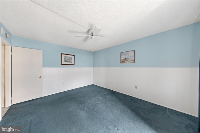 605 Chesapeake House Rd Unit 605N, Bethany Beach, DE 19930 - empty room featuring dark carpet, wainscoting, a ceiling fan, and a textured ceiling