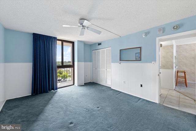 605 Chesapeake House Rd Unit 605N, Bethany Beach, DE 19930 - spare room featuring a textured ceiling, a ceiling fan, a wainscoted wall, and carpet