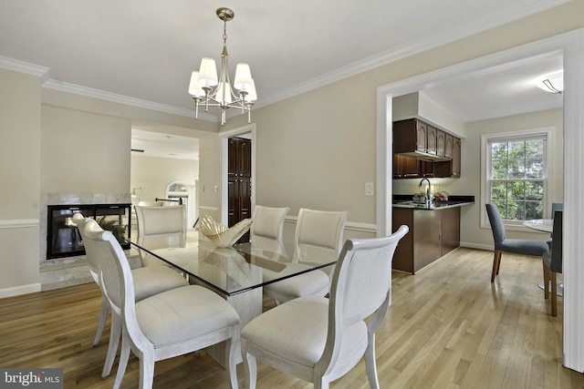 4714 Major Ct, Alexandria, VA 22312 - dining room with a chandelier, light wood-type flooring, a premium fireplace, crown molding, and baseboards