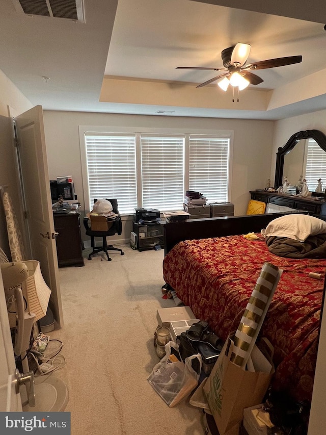 bedroom featuring light carpet, a desk, multiple windows, and ceiling fan