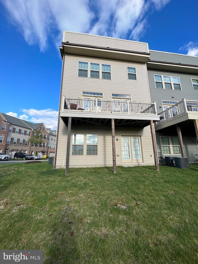 rear view of house with a yard and central air condition unit