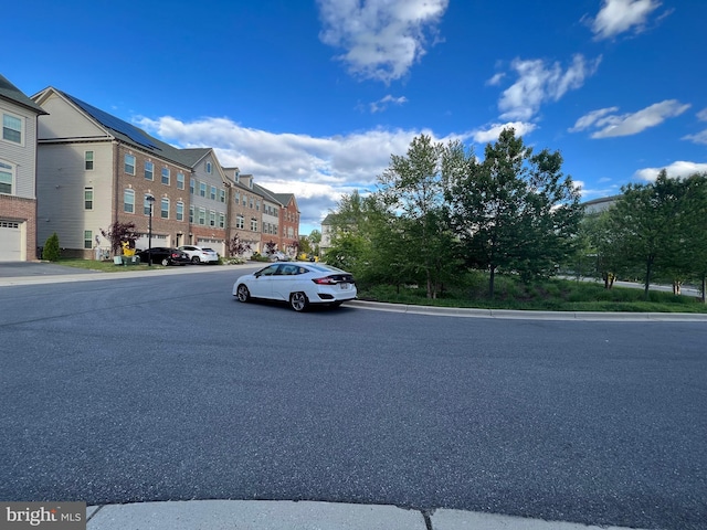 view of asphalt street with curbs