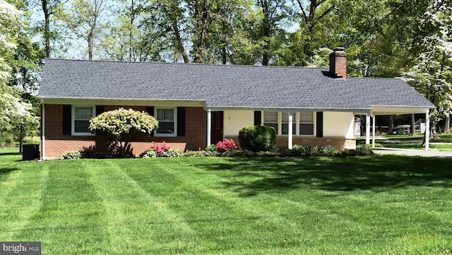 7 Tudor Ln, Bel Air, MD 21015 - view of front facade featuring brick siding, a front lawn, a chimney, and central AC