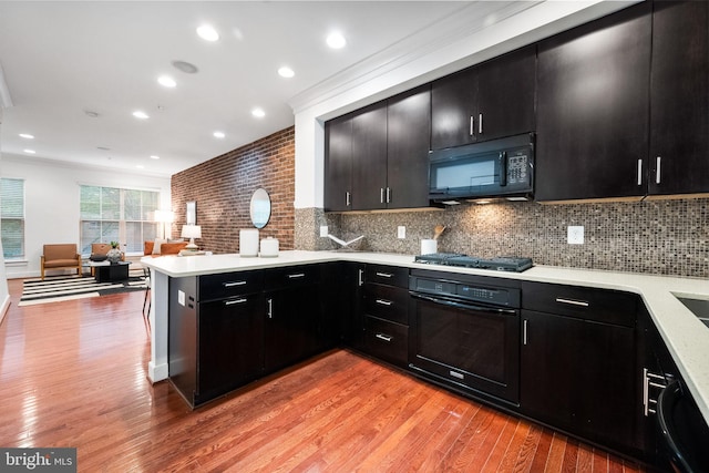 5711 45th Ave, Hyattsville, MD 20781 - kitchen featuring black appliances, dark cabinets, a peninsula, ornamental molding, and recessed lighting