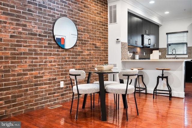 5711 45th Ave, Hyattsville, MD 20781 - dining space featuring wood finished floors, ornamental molding, recessed lighting, and brick wall