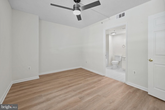 3830 9th St N Unit 110W, Arlington, VA 22203 - unfurnished bedroom featuring wood finished floors, a textured ceiling, ensuite bathroom, and a ceiling fan