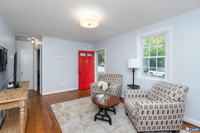 sitting room featuring wood-type flooring, baseboards, and plenty of natural light