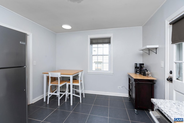 dining area with baseboards and dark tile patterned floors