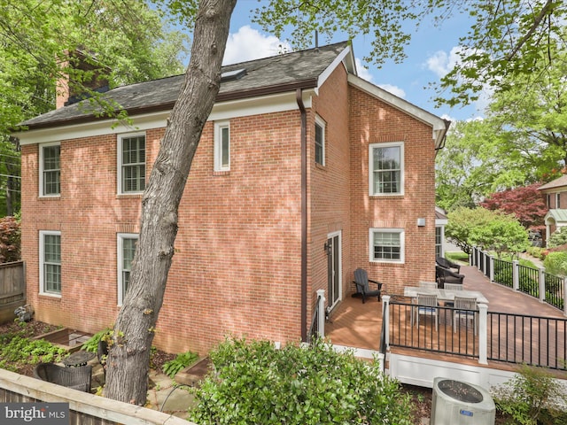 7287 Evans Mill Rd, Mclean, VA 22101 - back of property featuring outdoor dining space, a deck, central air condition unit, a chimney, and brick siding