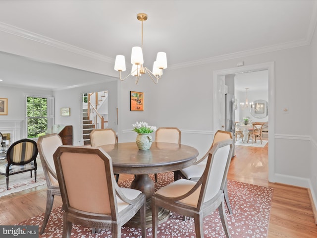 7287 Evans Mill Rd, Mclean, VA 22101 - dining space featuring a chandelier, stairs, light wood-style flooring, ornamental molding, and baseboards