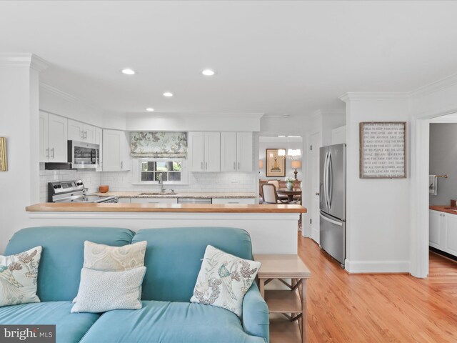 7287 Evans Mill Rd, Mclean, VA 22101 - kitchen with appliances with stainless steel finishes, a sink, backsplash, white cabinets, and crown molding