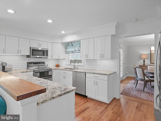 7287 Evans Mill Rd, Mclean, VA 22101 - kitchen featuring stainless steel appliances, a sink, white cabinetry, crown molding, and recessed lighting