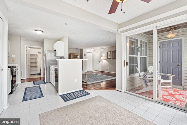 8357 Cypress Mill Rd Unit 8357, Nottingham, MD 21236 - kitchen featuring light tile patterned flooring, gas range, a textured ceiling, ceiling fan, and baseboards