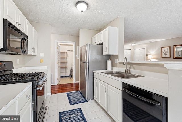 8357 Cypress Mill Rd Unit 8357, Nottingham, MD 21236 - kitchen with black appliances, a sink, white cabinetry, light countertops, and a textured ceiling